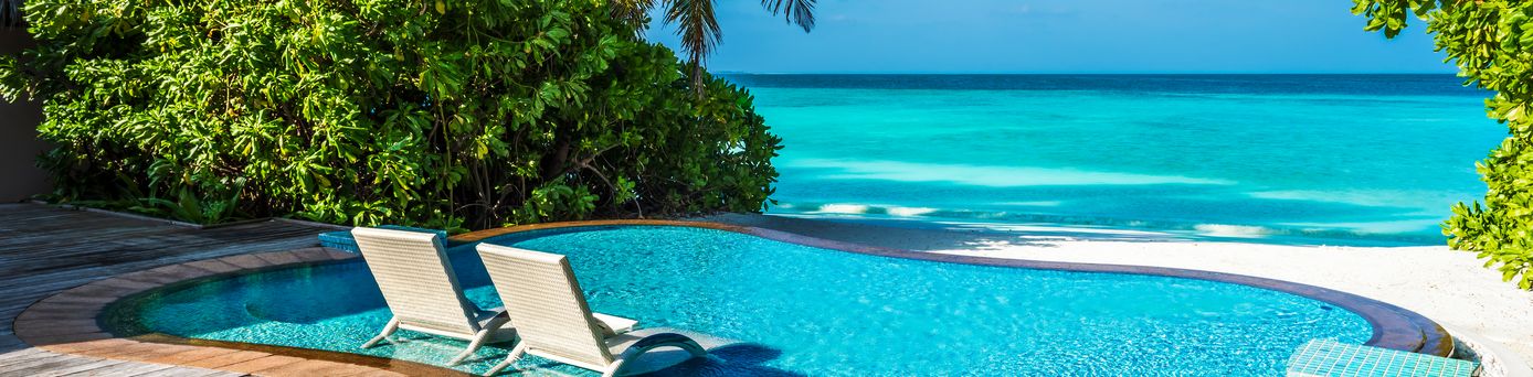 Ein kleiner Pool mit direktem Strandzugang und zwei Liegen