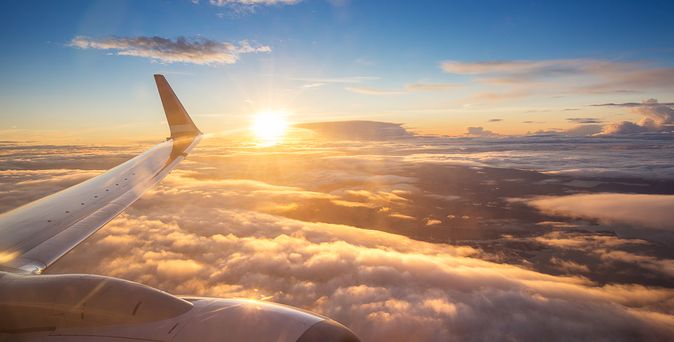 Sonnenuntergang über den Wolken aus einem Flugzeugfenster aus