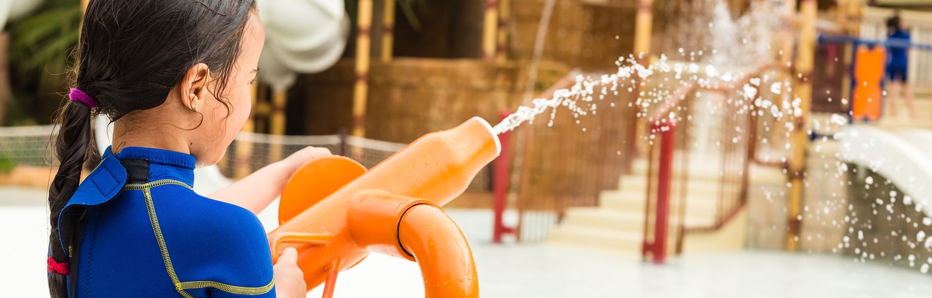 Kind spielt mit einer Wasserpistole in einem Aquapark