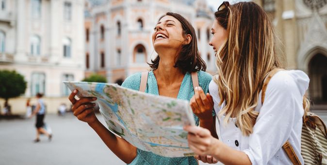 Zwei lachende Frauen mit einem Stadtplan