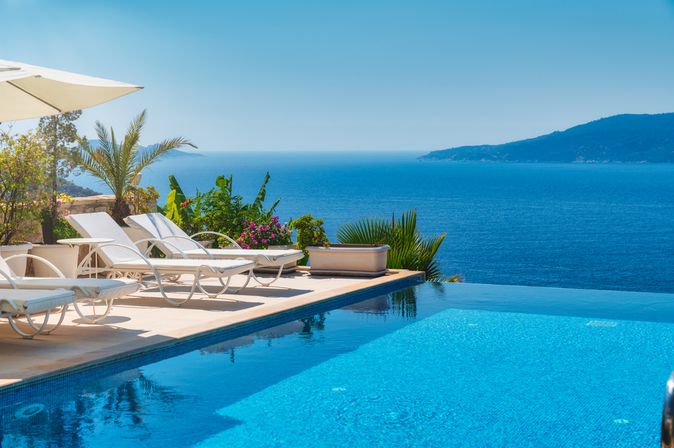 Infinity Pool mit Liegen und Blick auf das Meer
