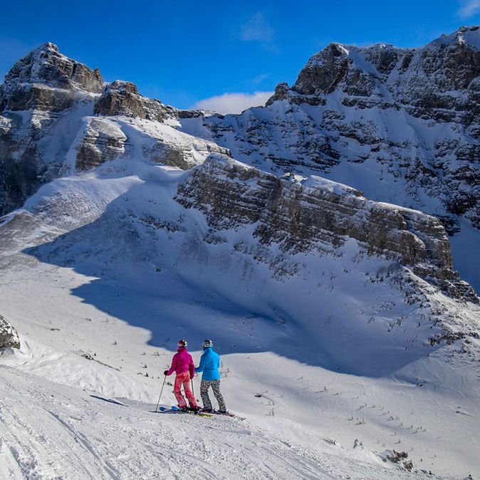 Zwei Menschen auf Skiern laufen durch eine verschneite Berglandschaft