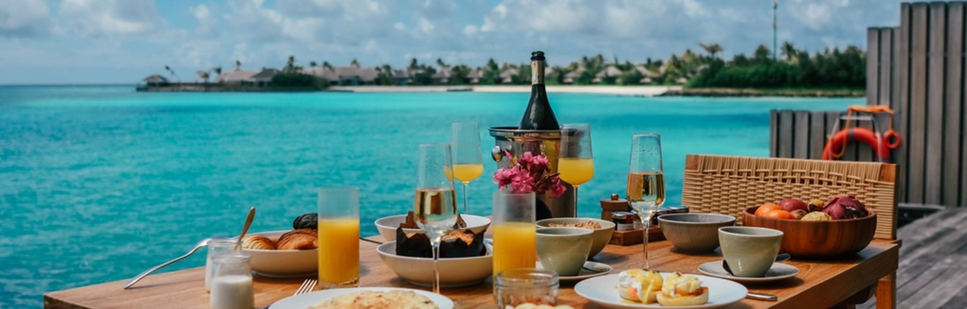 Ein gedeckter Frühstückstisch auf einer Terrasse mit direktem Meerzugang