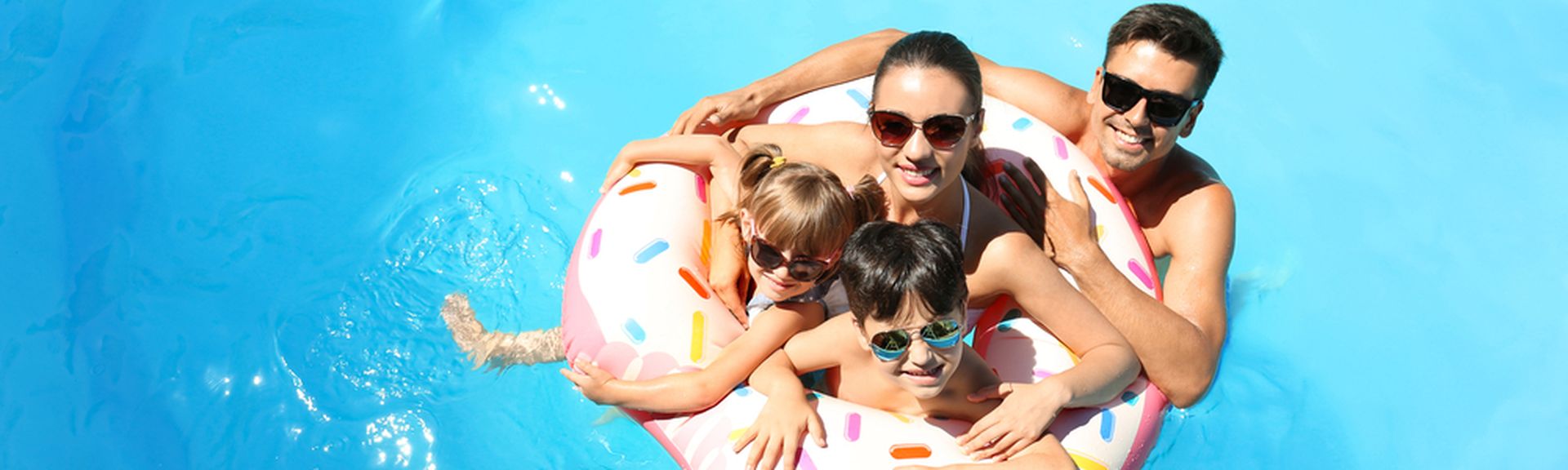Eine Familie mit zwei Kindern und ein Schwimmreifen in einem Pool