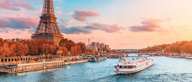 Flusskreuzfahrtschiff auf der Seine neben dem Eiffelturm in Paris