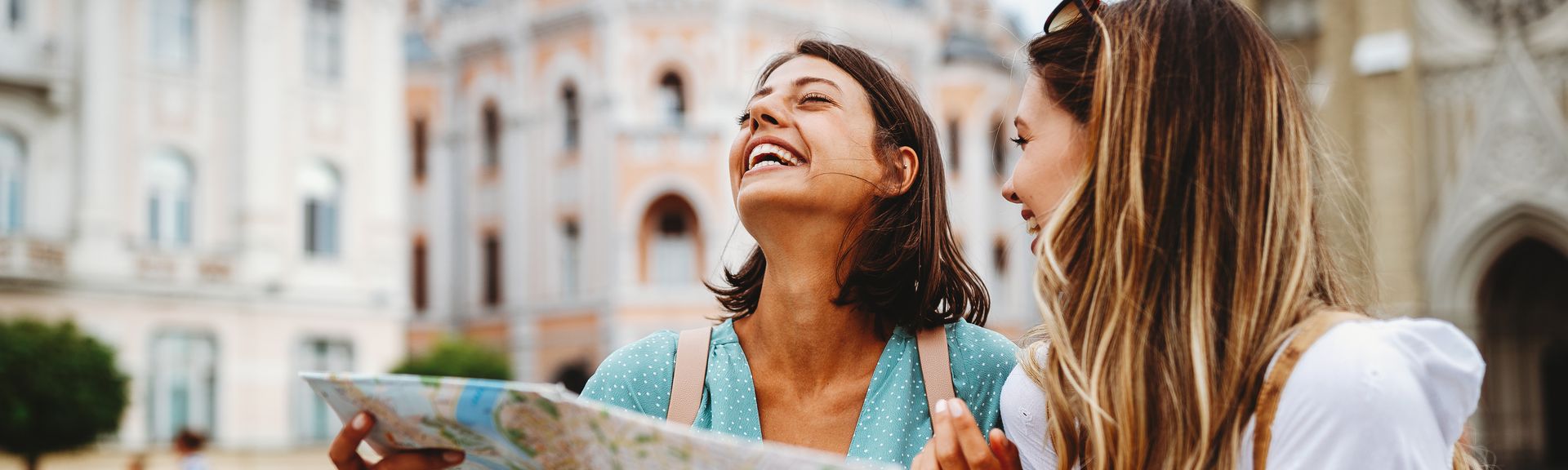 Zwei lachende Frauen mit einem Stadtplan