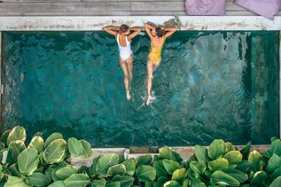 Zwei Frauen liegen im Pool und schauen sich an