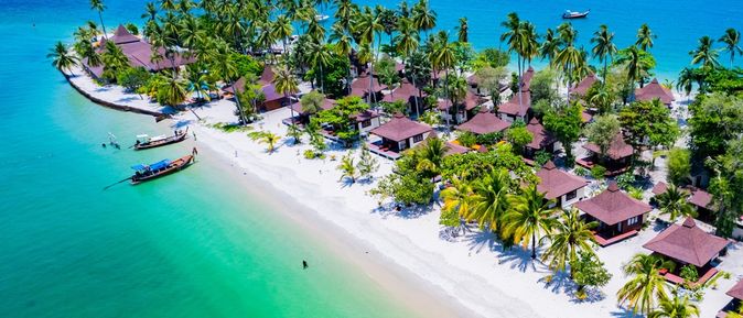 Teil einer Insel mit kleinen Häusern und Palmenstrand