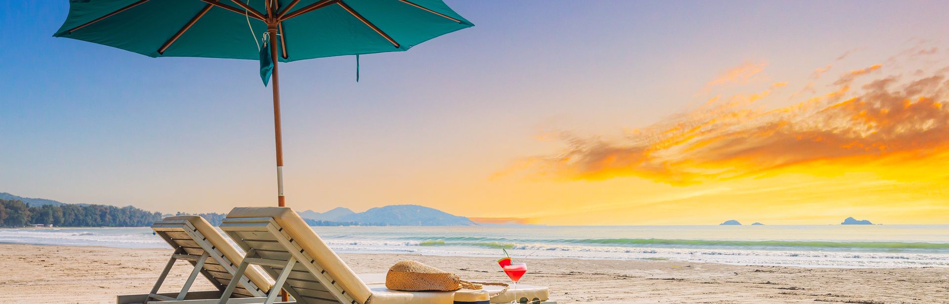 Zwei Liegen mit Sonnenschirm stehen am Strand