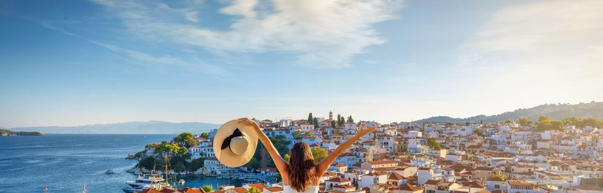 Eine glückliche Touristin genießt den schönen Sonnenuntergang im Sommer mit Blick auf die Stadt 