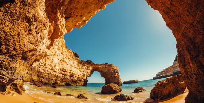 Blick auf einen Strand unter einem Felsdach.