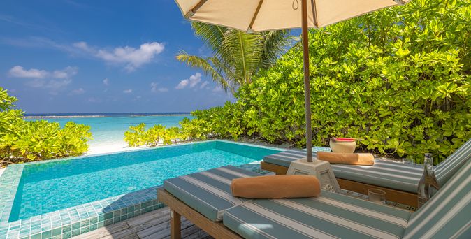 Private Pool mit zwei Liegen und einem Sonnenschirm