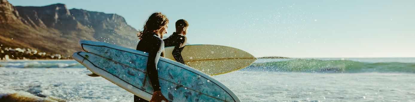 Surfer laufen auf das Meer zu