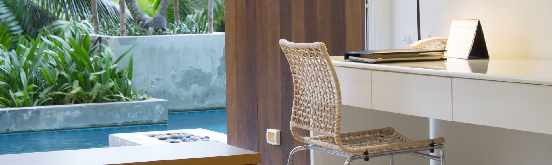 Ein Hotelzimmer mit Schreibtisch, im Hintergrund ein Swim-up Pool