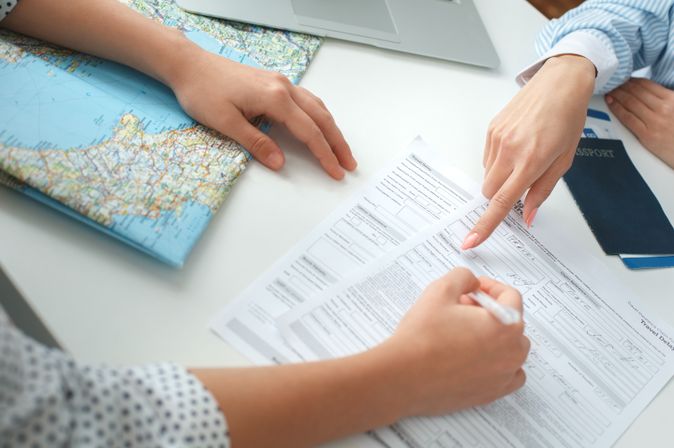 Zwei Personen füllen Reiseunterlagen aus