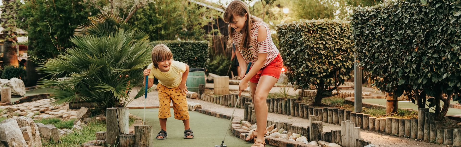 Zwei Kinder spielen Minigolf in einem Clubhotel