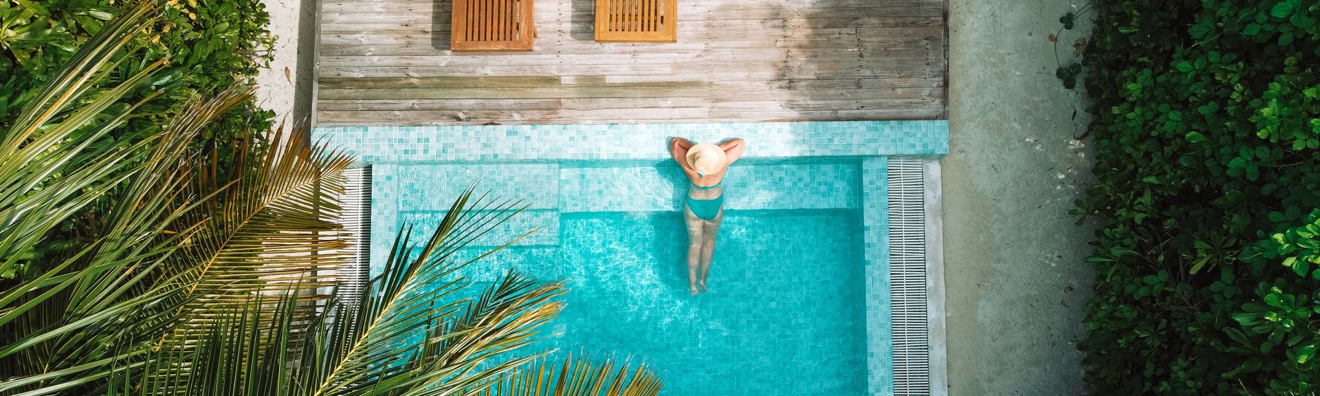 Eine Frau lehnt am Rand eines eleganten Pools