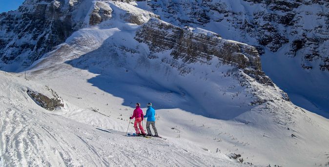 Zwei Menschen auf Skiern laufen durch eine verschneite Berglandschaft