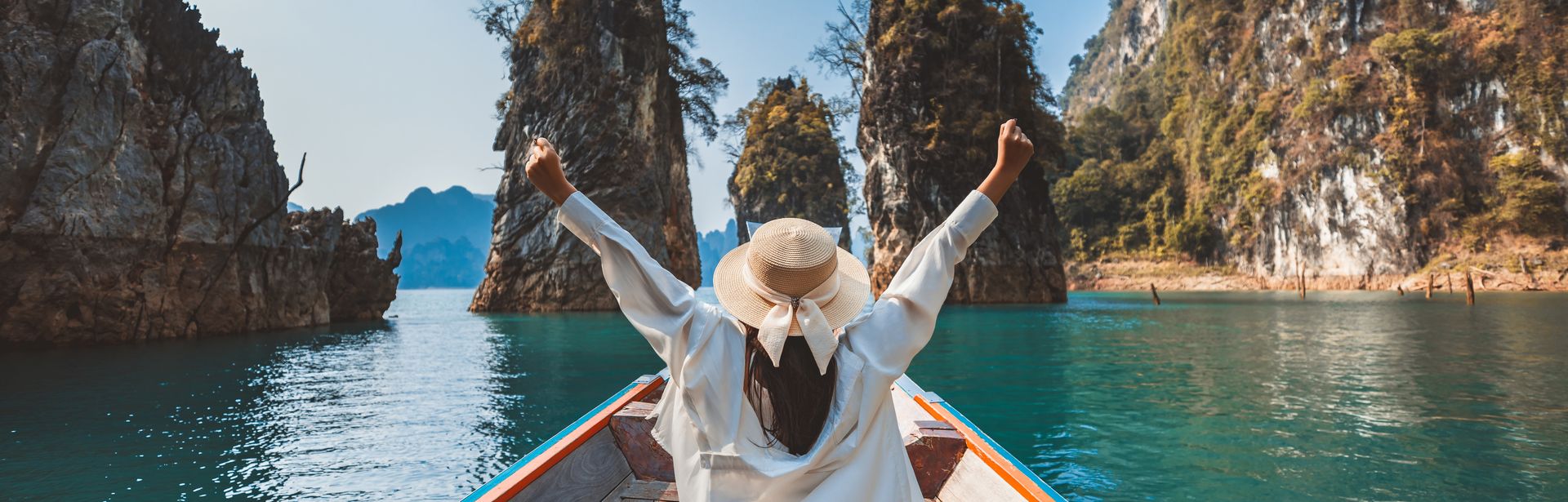 Alleinreisende Frau in einem Boot auf dem Wasser in Thailand