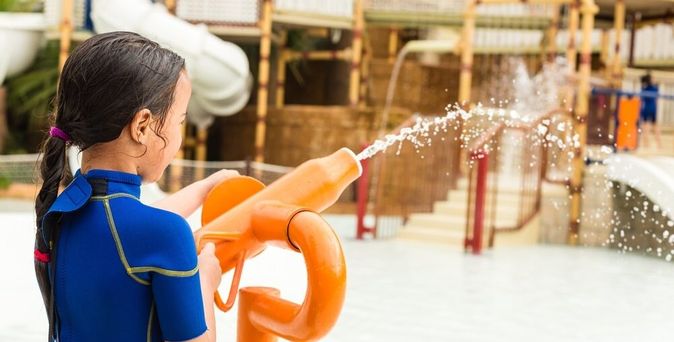 Kind spielt mit einer Wasserpistole in einem Aquapark