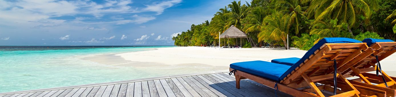 Zwei Liegen auf einer Terrasse mit Strandzugang