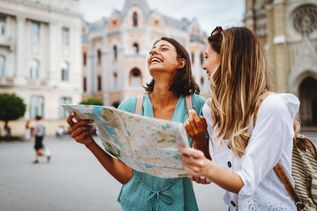 Zwei lachende Frauen mit einem Stadtplan