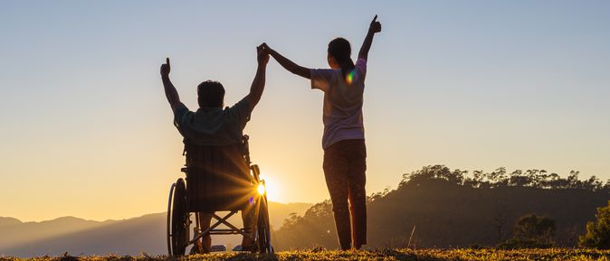 Silhouette von zwei Personen, Heben die Arme beim Sonnenuntergang