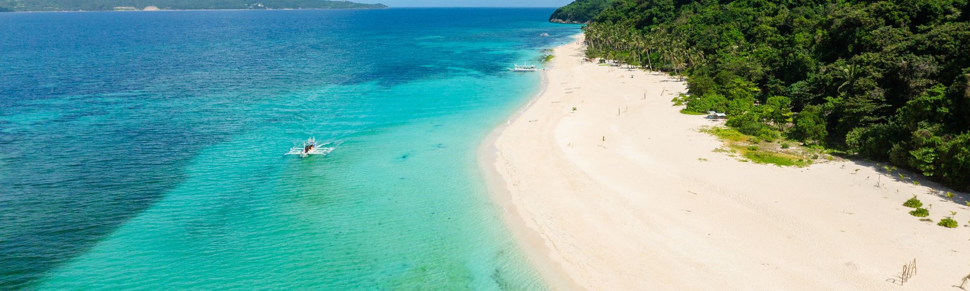 Sandstrand einer Insel mit einem Wald