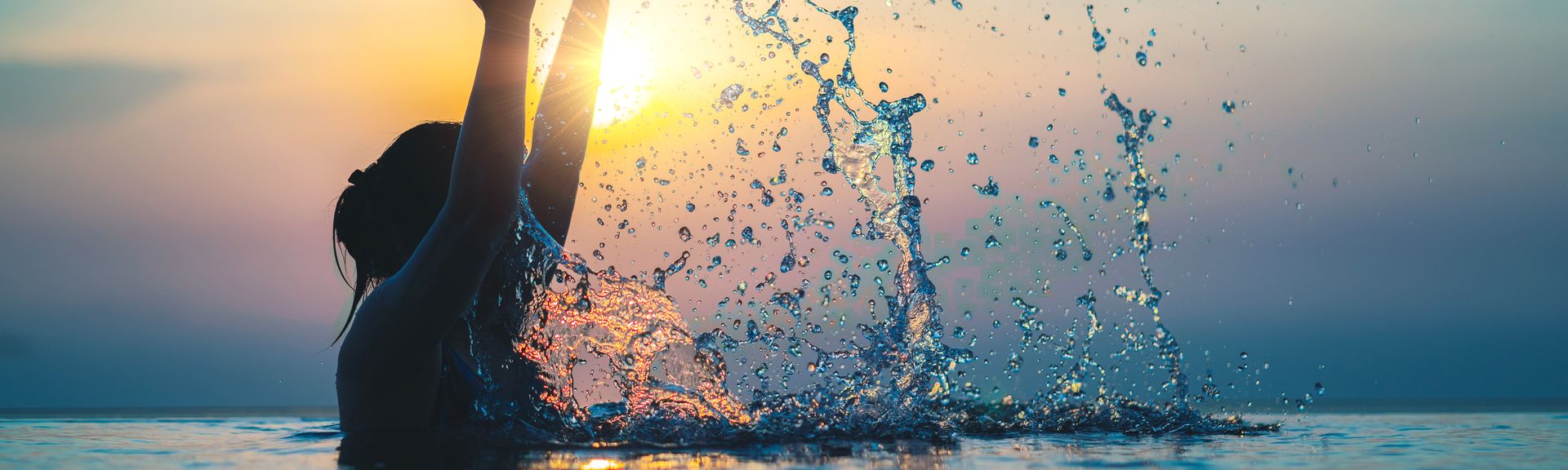 Frau im Pool bei Sonnenuntergang 