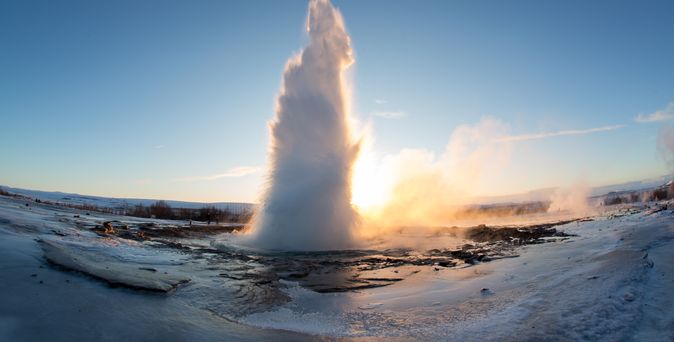 Ein Geysir bricht aus und schießt eine große Wassersäule in die Luft