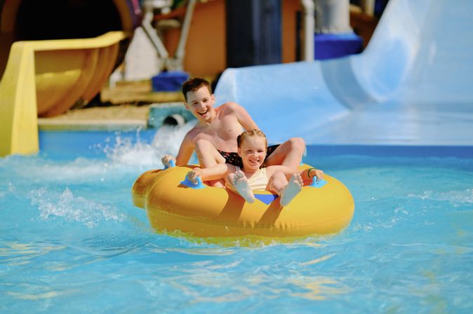 Zwei Kinder auf einem Schwimmring in einem Aquapark