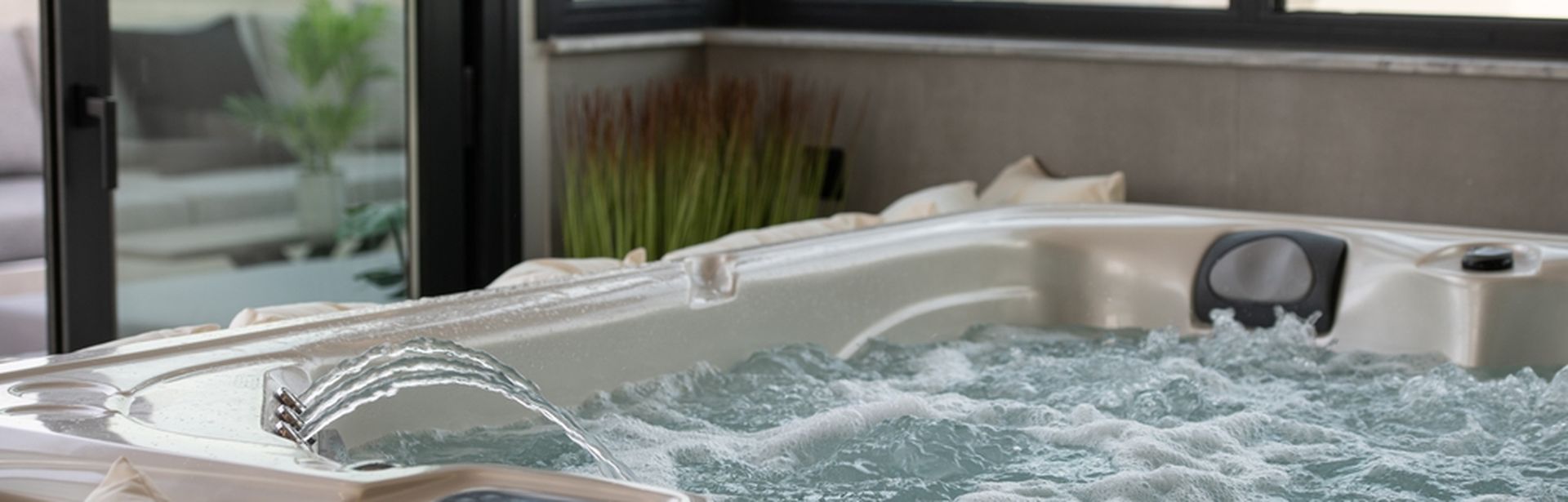 Whirlpool der blubbert und in den Wasser eingelassen wird. Vor dem Whirlpool ist eine Reihe von Kissen