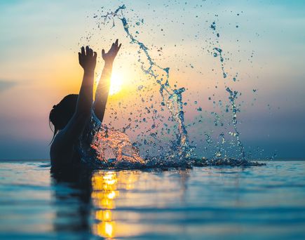 Frau im Pool bei Sonnenuntergang 