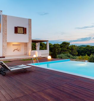 Privater Pool bei Dämmerung mit einem Haus im Hintergrund