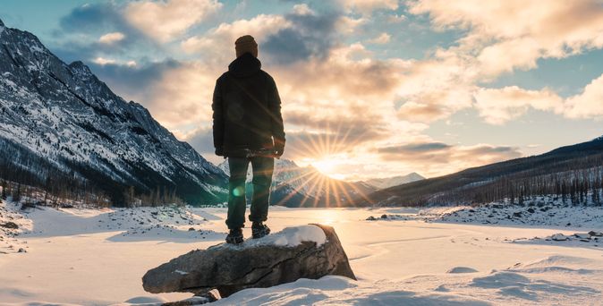 Mann schaut auf schneebedeckten See