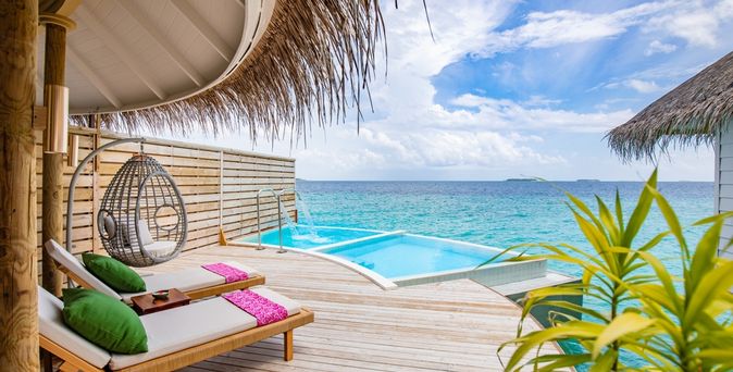 Eine Terrasse mit Privatpool und gemütlichen Liegen über dem Meer
