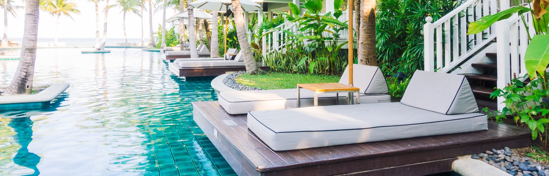 Zwei Liegen mit Sonnenschirm an einem Swim Up Pool