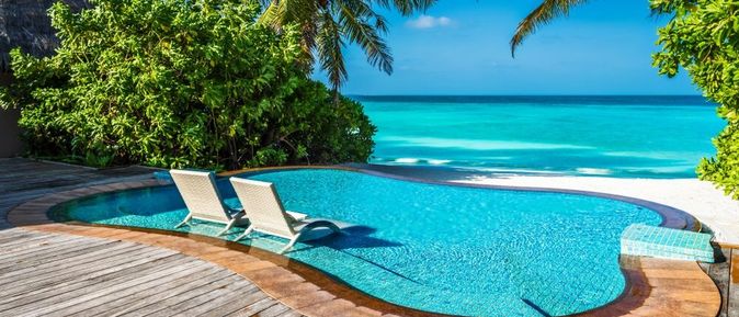 Ein kleiner Pool mit direktem Strandzugang und zwei Liegen