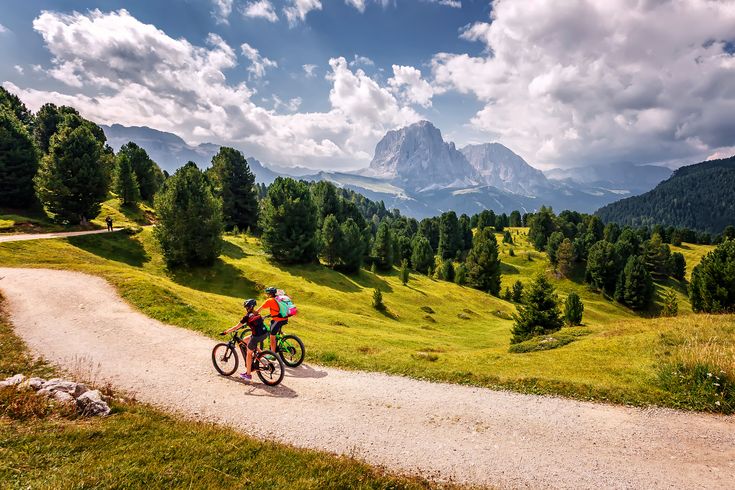 Zwei Personen fahren bei gutem Wetter Fahrrad durch eine Berglandschaft