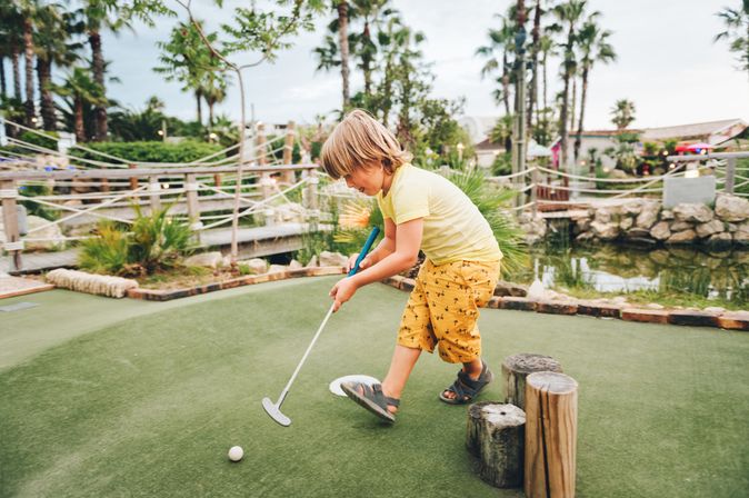 Ein junge spielt Minigolf