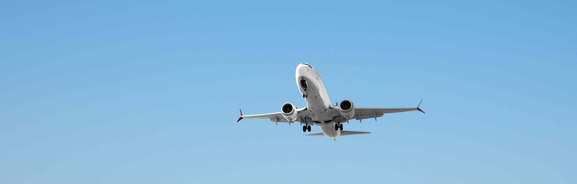 Flugzeug, vor blauem wolkenfreien Himmel von schräg unten fotografiert