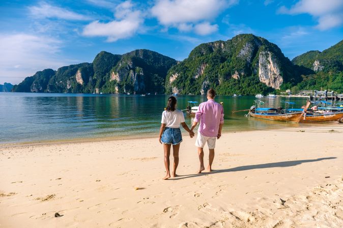 Ein Paar steht am Strand und hält Händchen