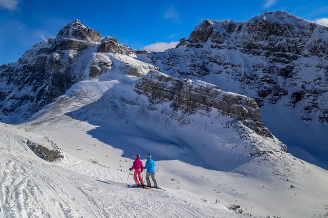 Zwei Menschen auf Skiern laufen durch eine verschneite Berglandschaft