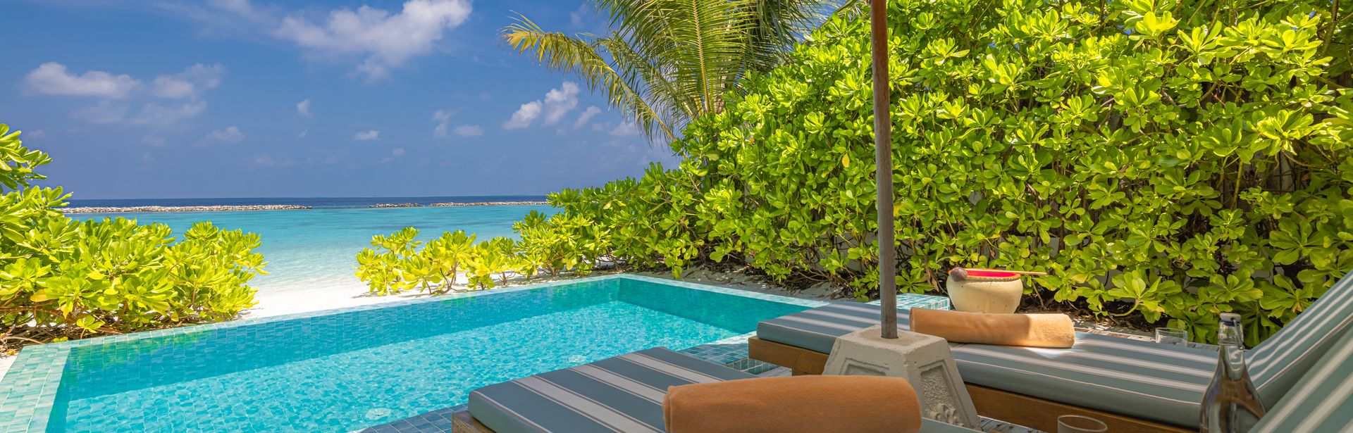 Private Pool mit zwei Liegen und einem Sonnenschirm