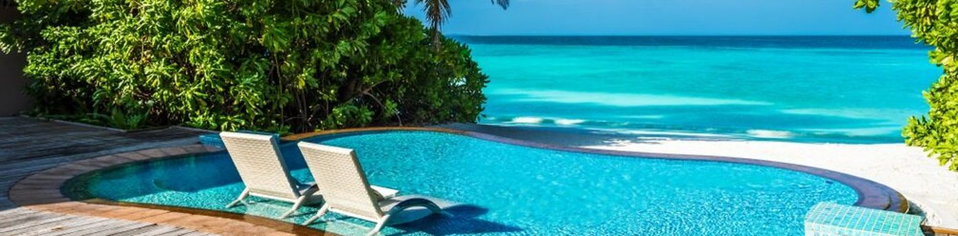 Ein kleiner Pool mit direktem Strandzugang und zwei Liegen