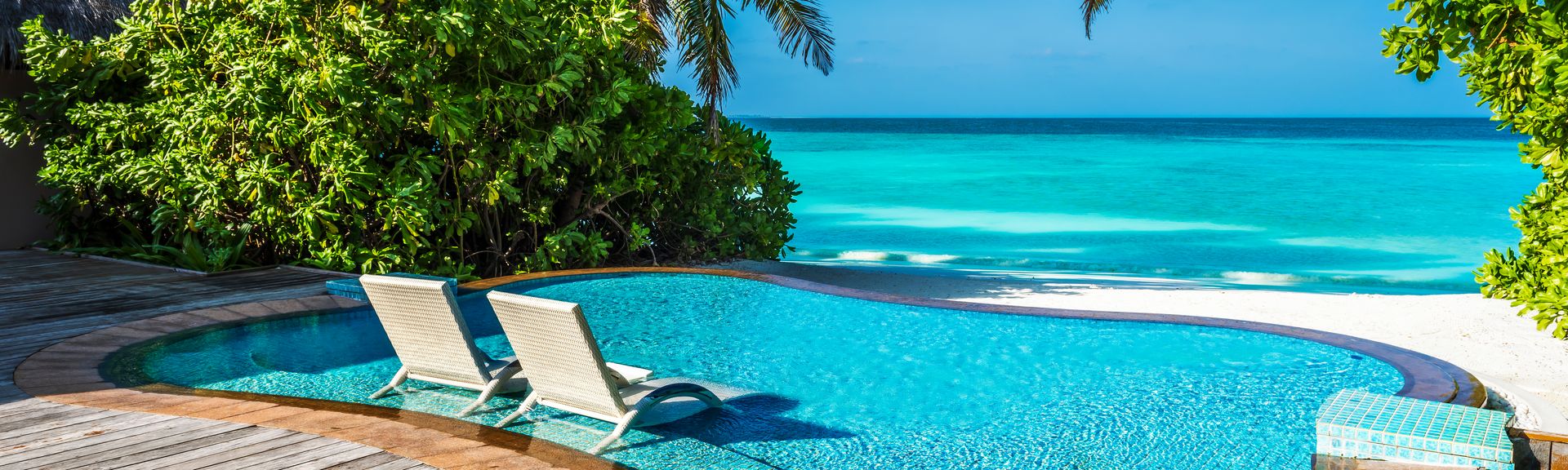 Ein kleiner Pool mit direktem Strandzugang und zwei Liegen