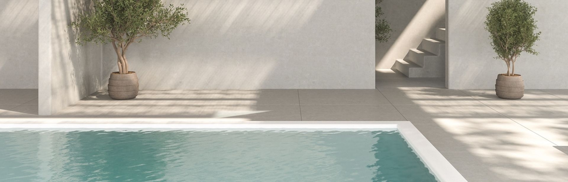 Ecke eines Pools. Im Hintergrund stehen zwei Topfpflanzen und ein Treppenaufgang ist zu sehen