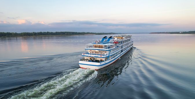 Flusskreuzfahrtschiff, dass auf einem breiten Fluss fährt