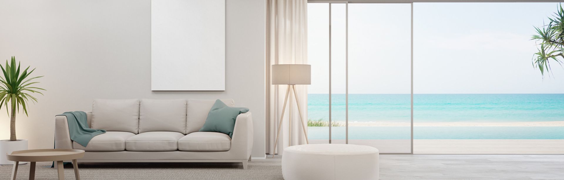 Blick auf das Sofa in einem Hotelzimmer. Rechts davon ist eine Glasfront mit offener Tür, die zu einem Pool führt. Das Meer ist im Hintergrund zu sehen