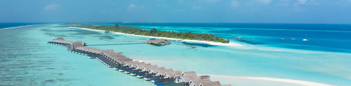 Reihe von Wasserbungalows vor einer Insel